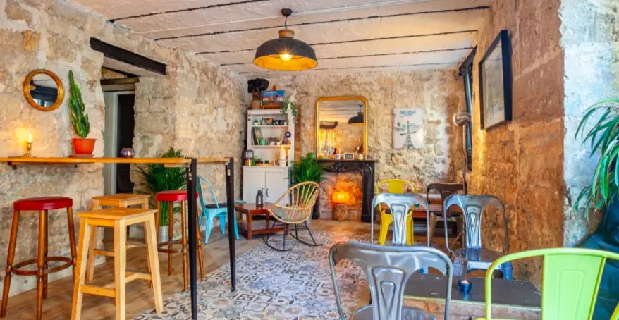 intérieur bar murs de pierre chaises colorées table haute